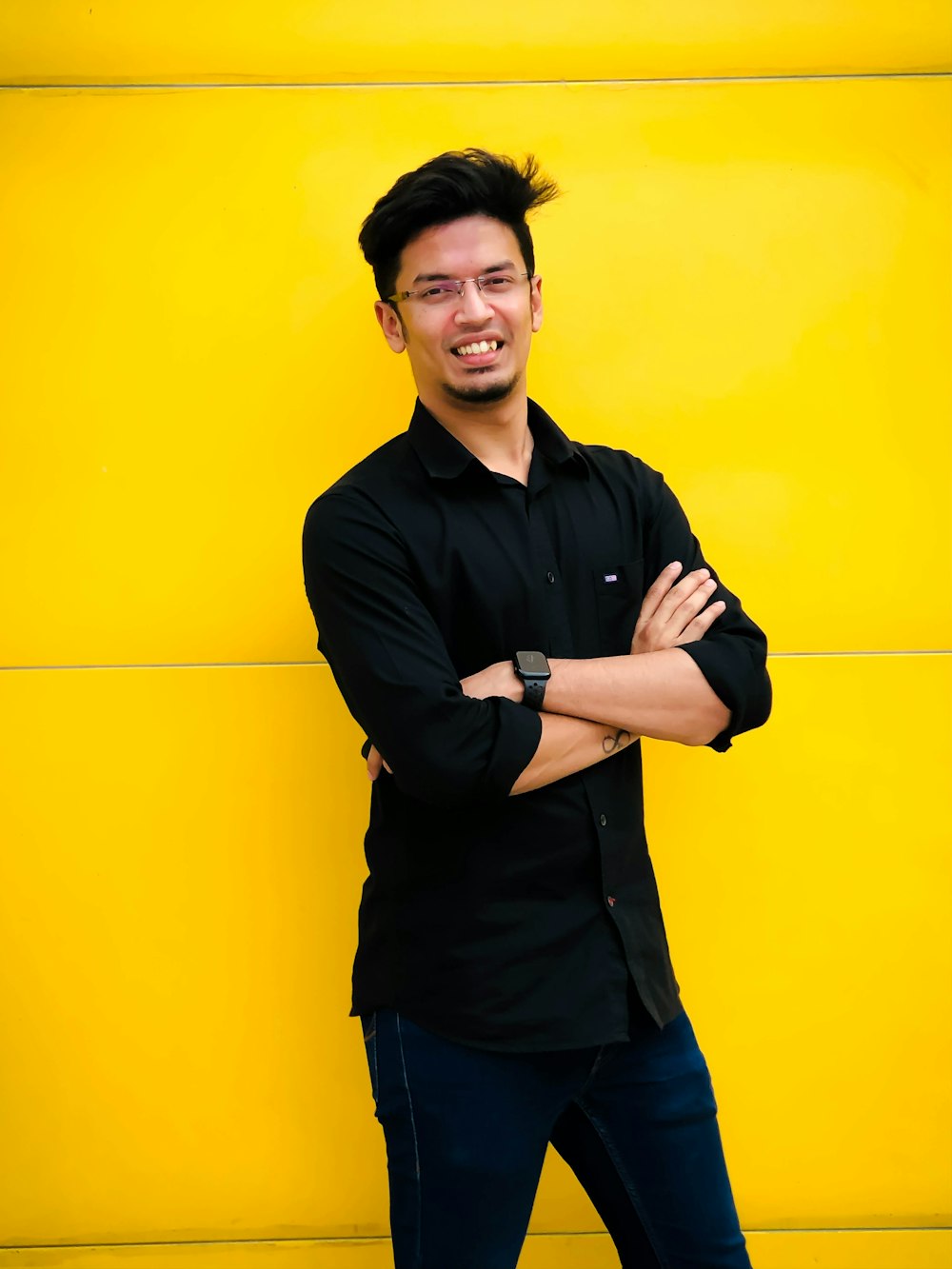 a man standing in front of a yellow wall