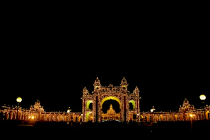 A stunning twilight view of Shiva Palace’s illuminated exterior with golden lights glowing against the dark sky.
