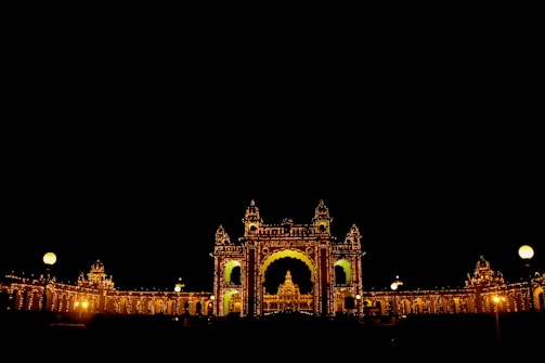 The majestic Mysore Palace glowing warmly under evening lights, showcasing royal architecture.