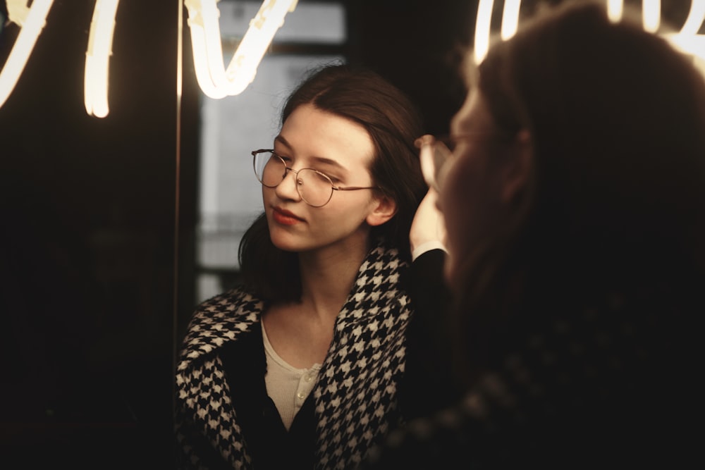 a woman looking at herself in the mirror