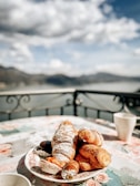 A charming café terrace overlooking a serene Swiss lake with pastries and coffee on the table.