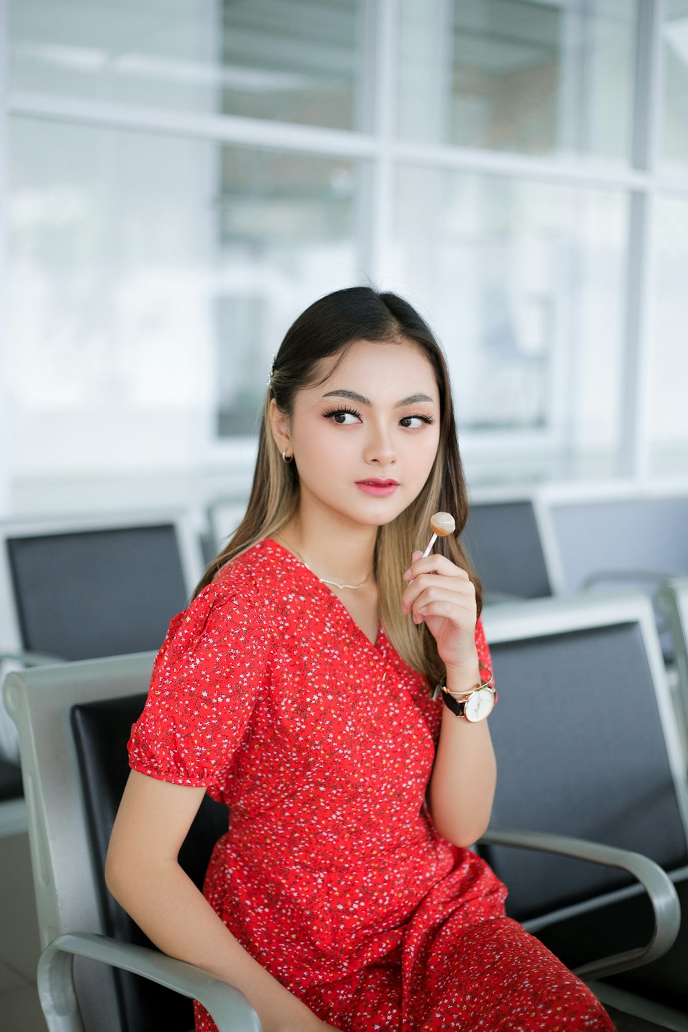 a woman in a red dress sitting on a chair