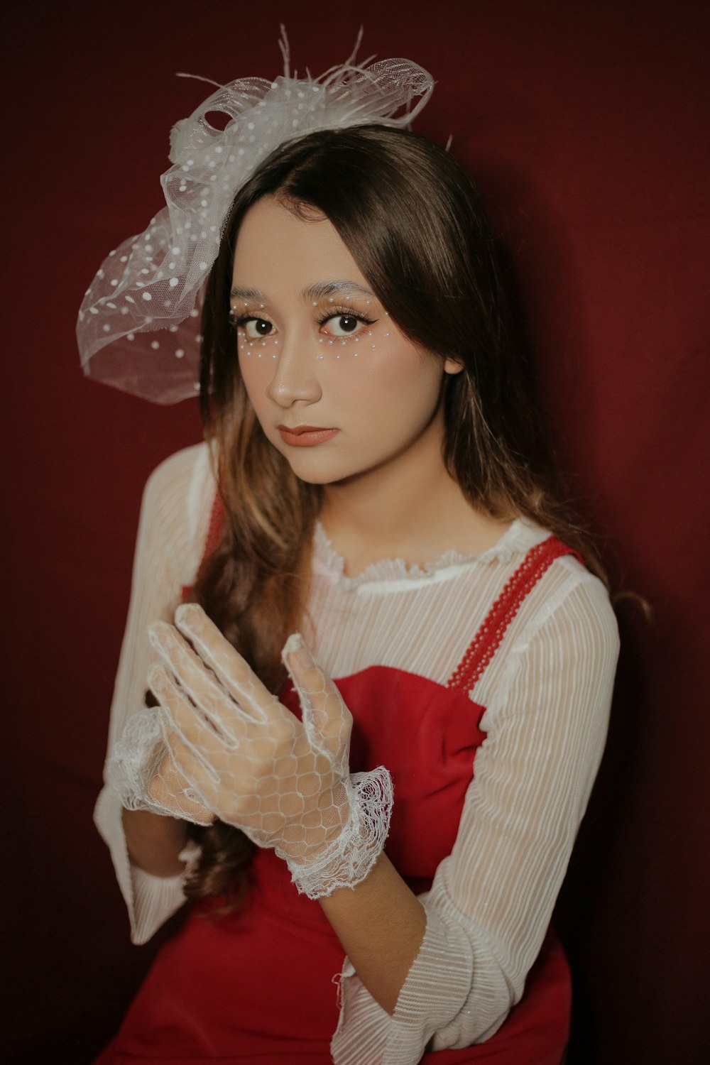 a woman wearing a red dress and white gloves