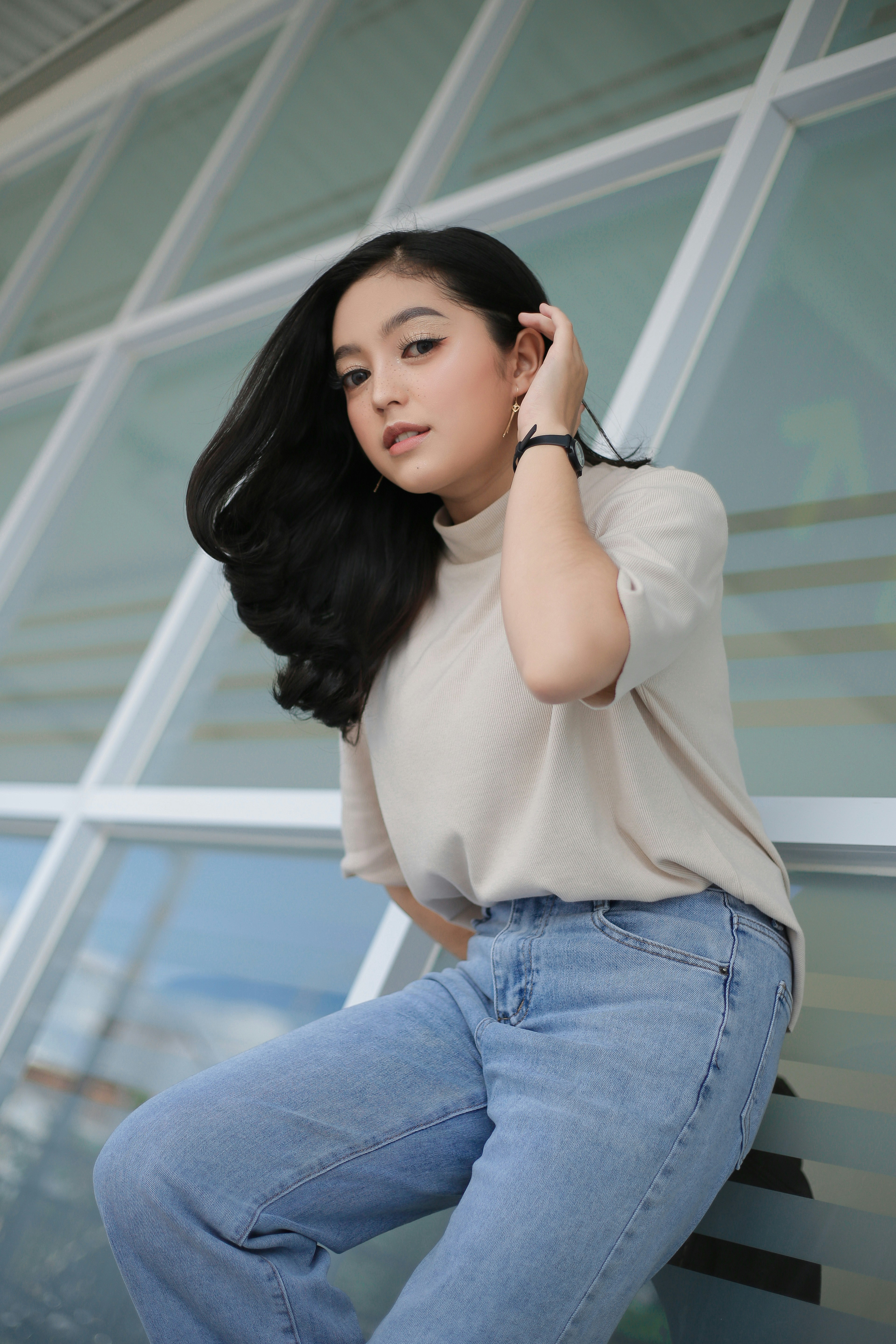 A woman leaning against a wall with her hand on her head photo – Free ...