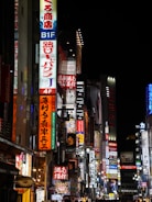 A bustling street in Tokyo lit up with neon signs at night.