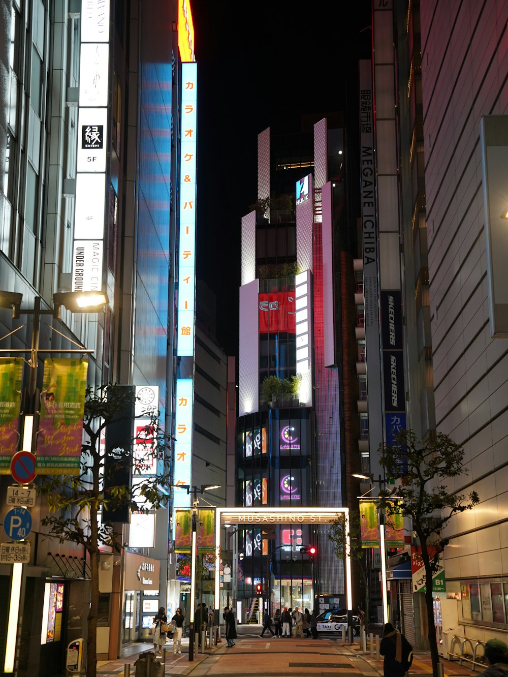 a city street at night with tall buildings