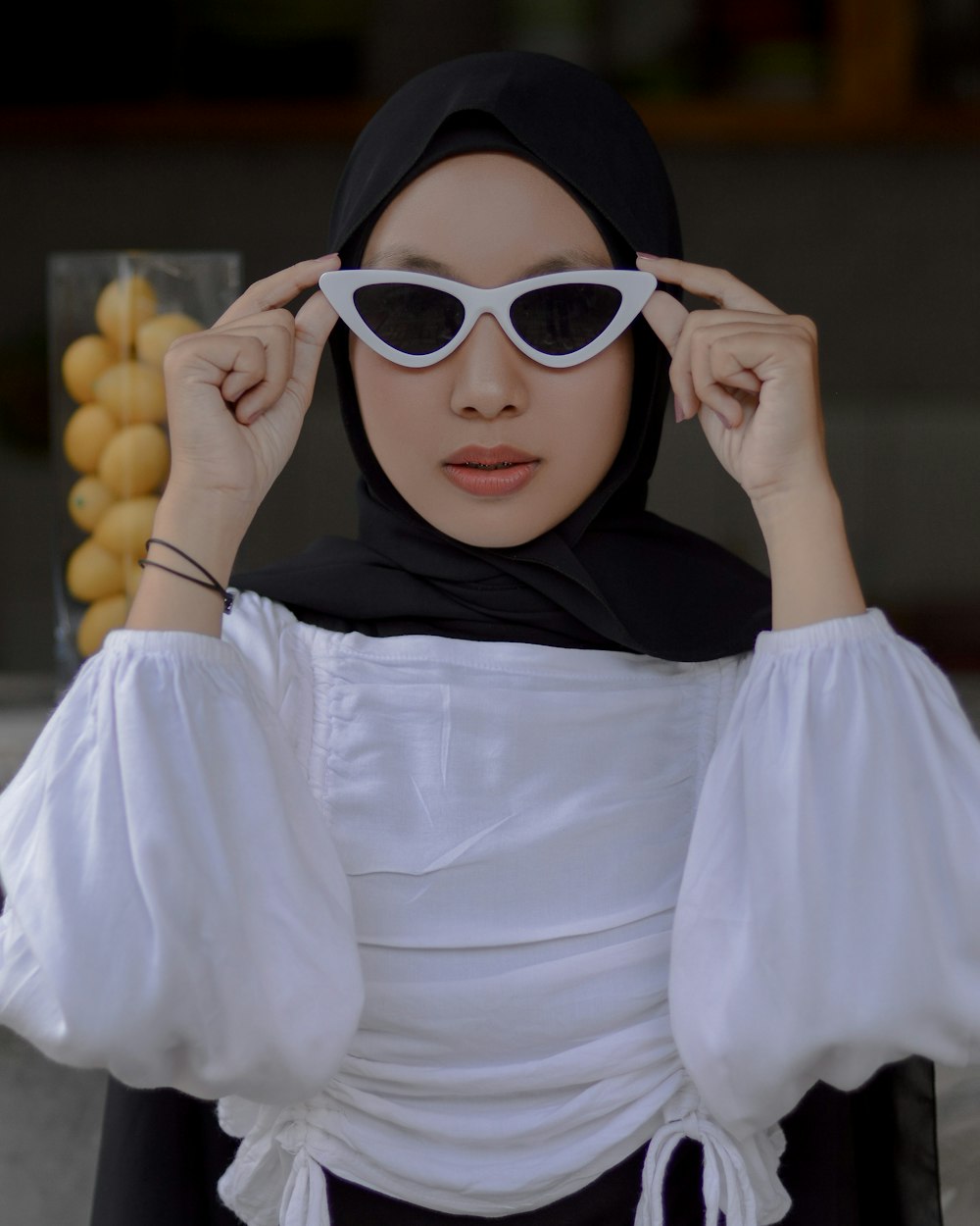 a woman in a hijab and white sunglasses