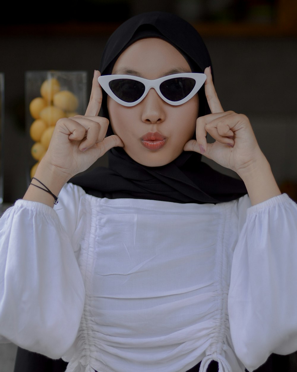 a woman wearing a white dress and black sunglasses