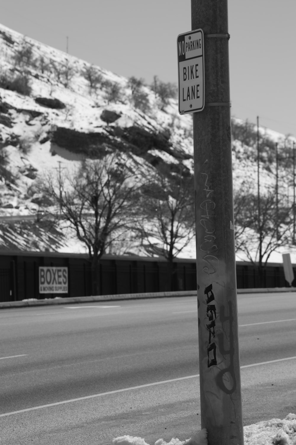 a street pole with graffiti on it next to a road