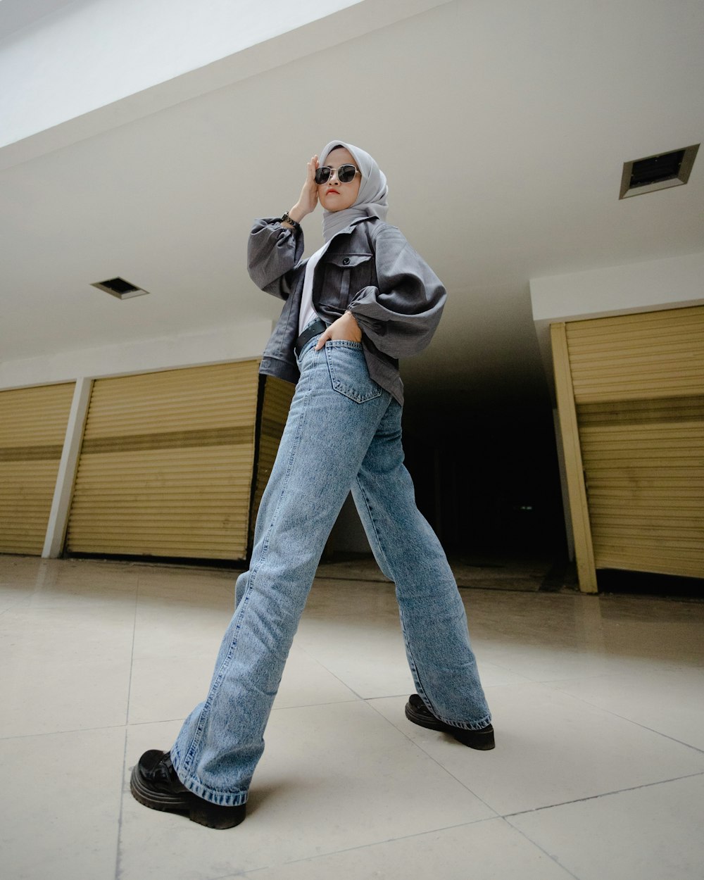 a woman in jeans and a hoodie is talking on a cell phone