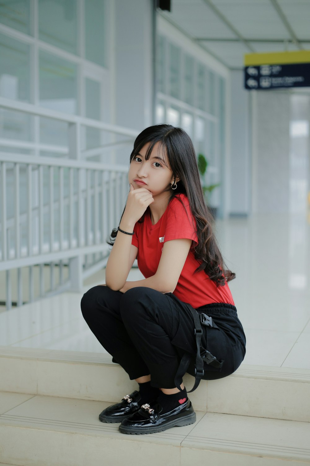 Une femme assise sur les marches d’un aéroport