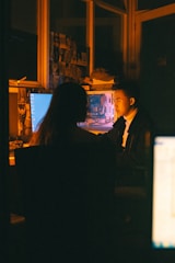 a man and a woman sitting in front of a computer