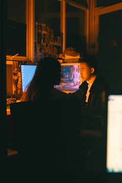 a man and a woman sitting in front of a computer