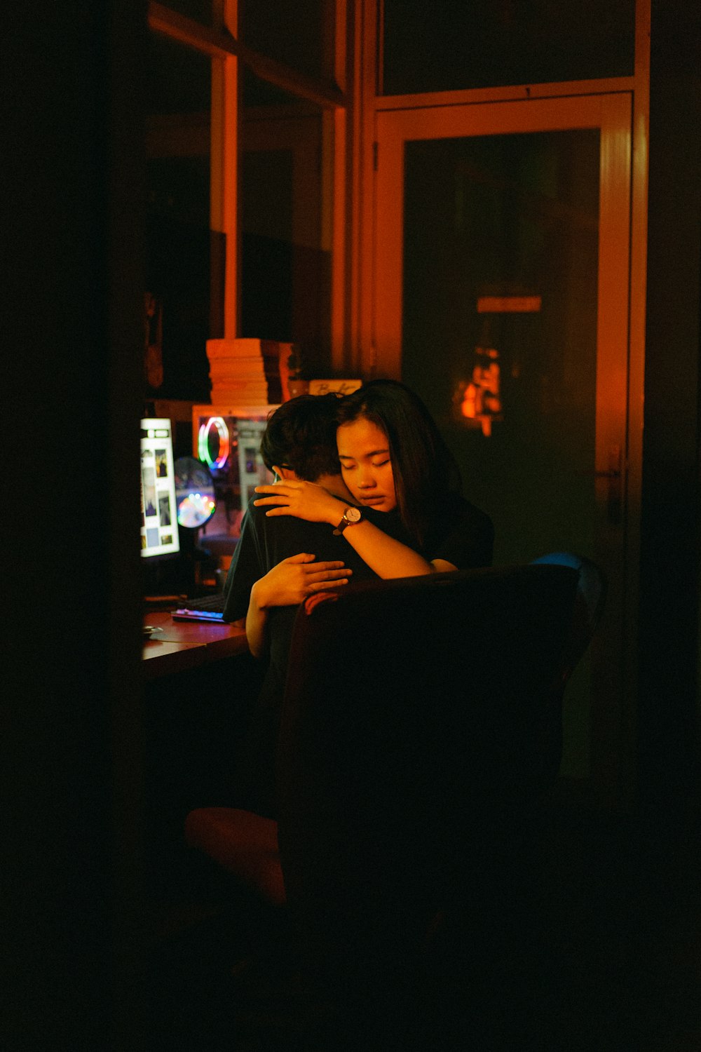uma mulher sentada em uma cadeira em um quarto escuro