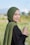 a woman in a hijab standing in a field