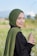 a woman in a hijab standing in a field