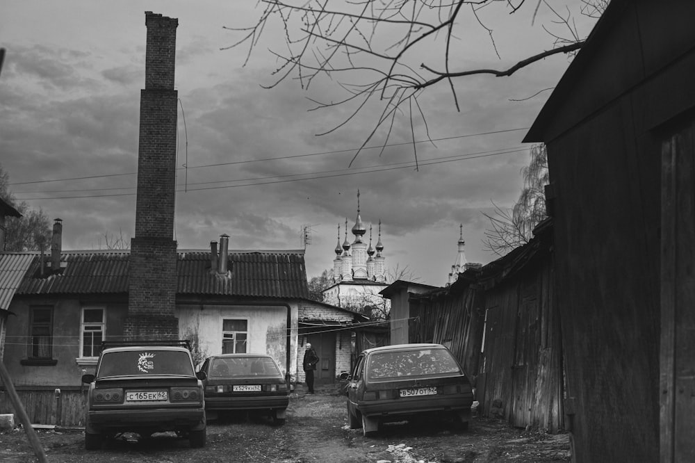 Una foto in bianco e nero di auto parcheggiate di fronte a un edificio