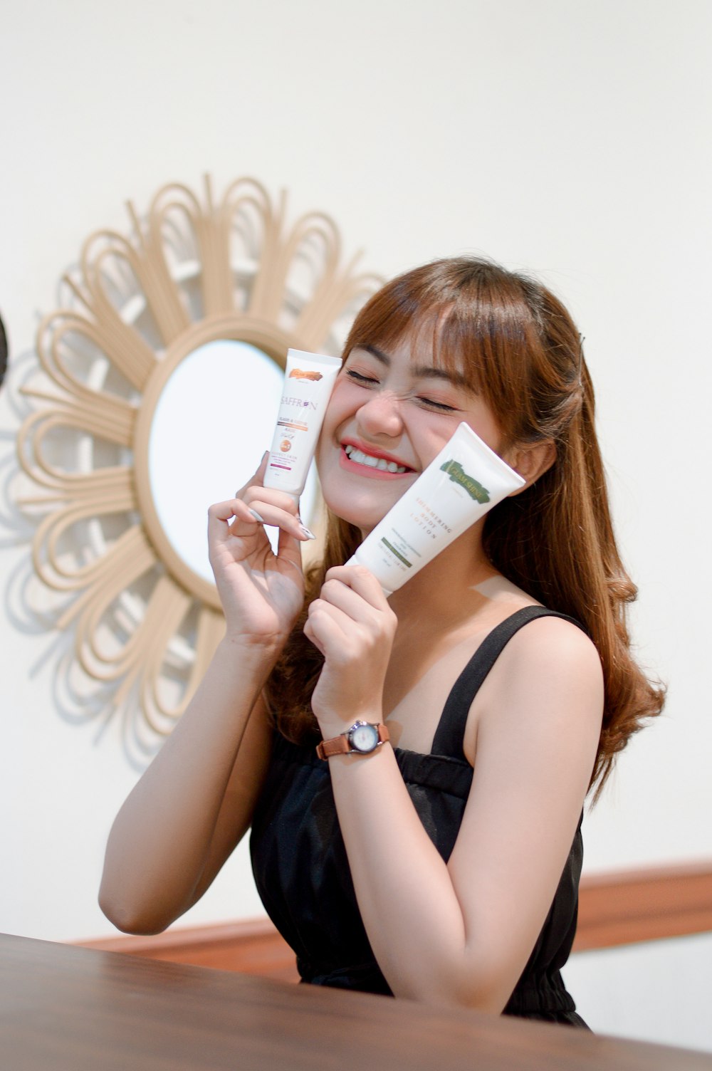 a woman holding a tube of cream and a tube of toothpaste