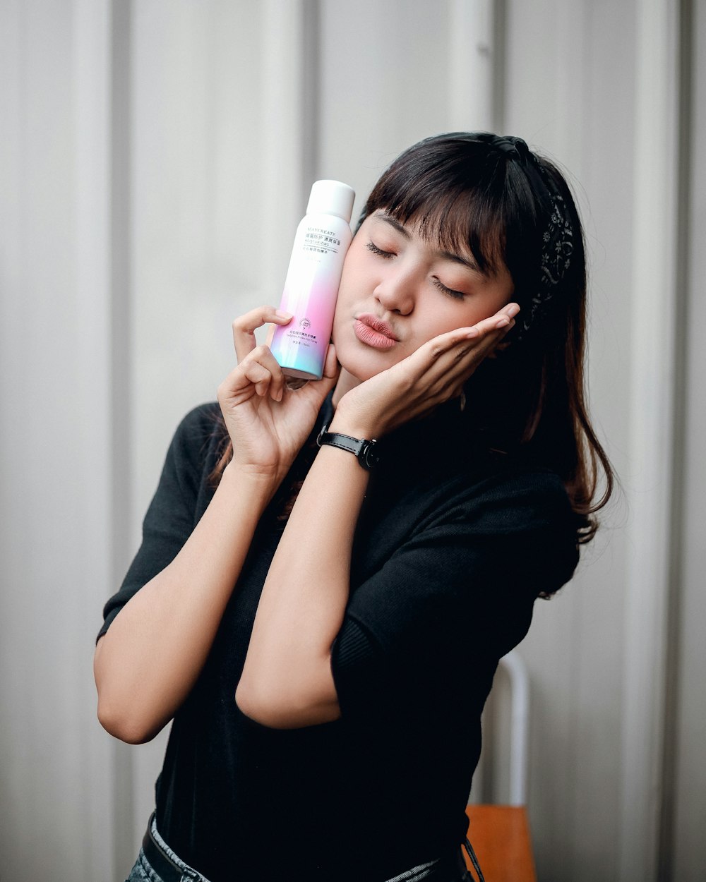 a woman holding a bottle of lotion in her hand