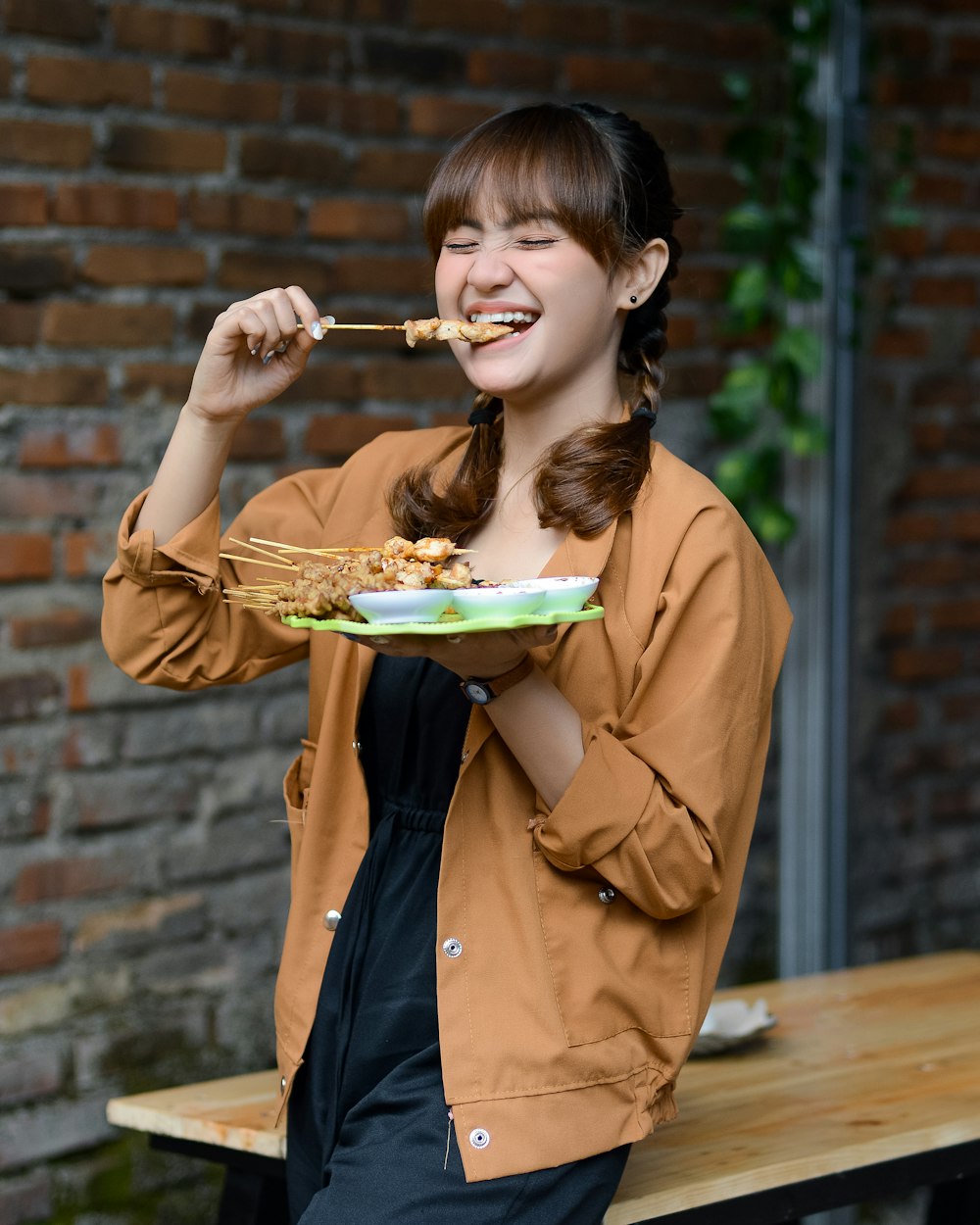 a woman eating food from a plate on a table