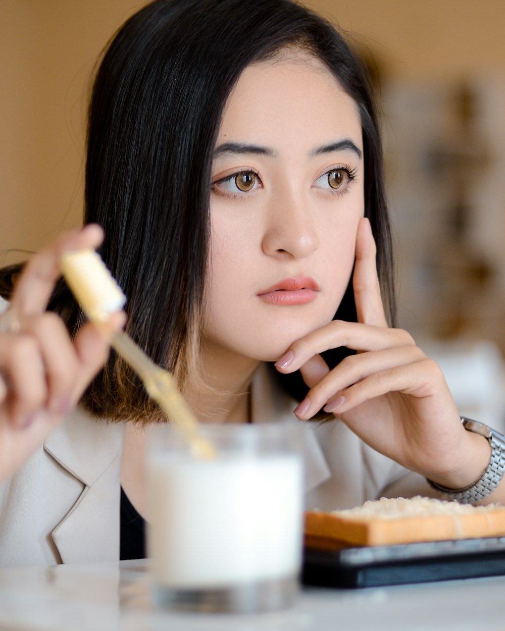 a woman sitting at a table with a plate of food and a glass of milk