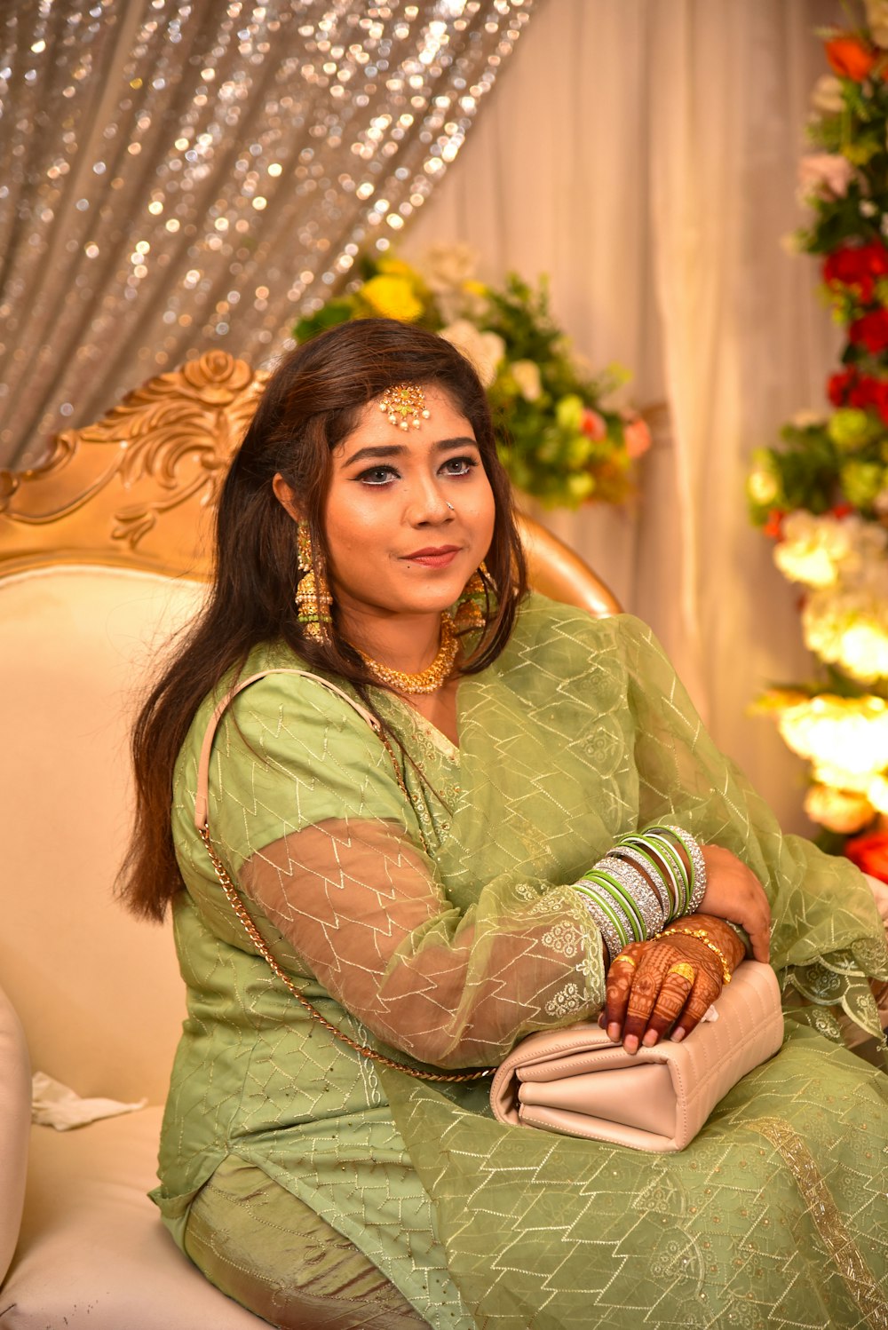 a woman in a green dress sitting on a couch