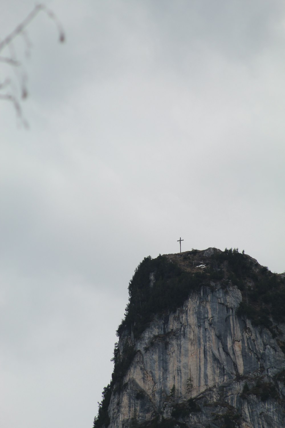 a cross on top of a mountain on a cloudy day