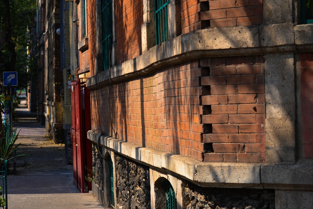 a red brick building with green shutters on the side