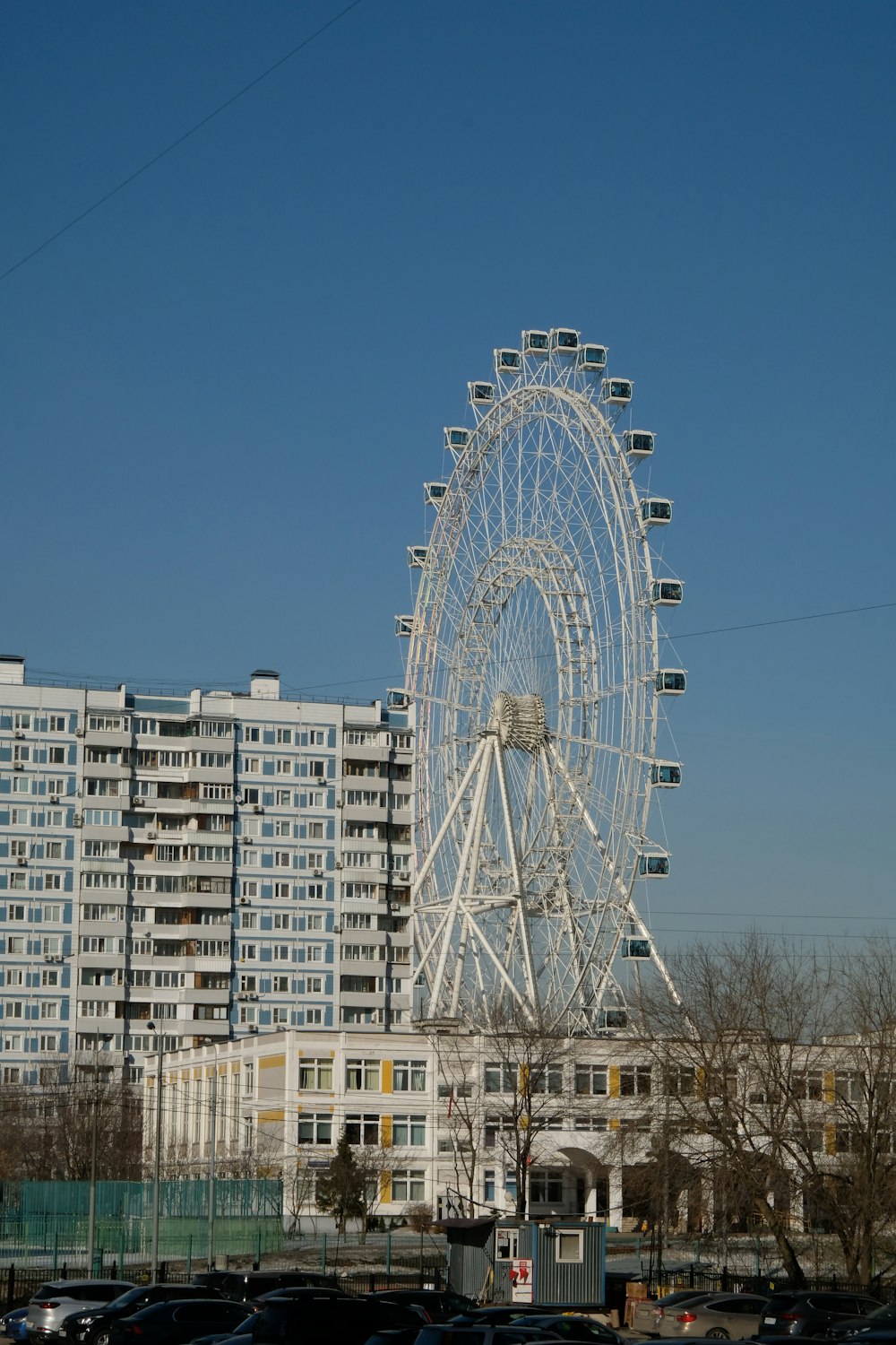 a large ferris wheel sitting in front of a tall building