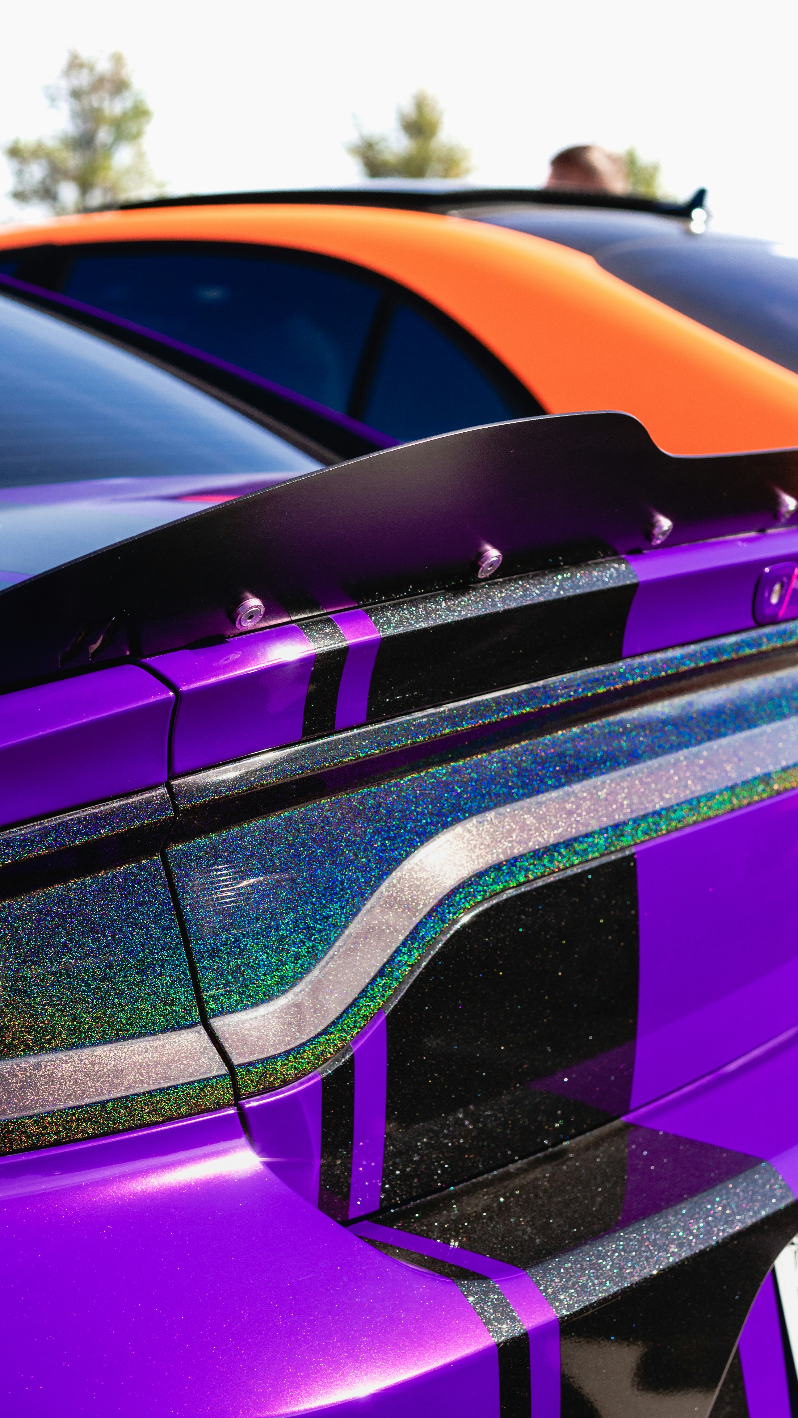 Ein Auto mit irisierender Folie, das in sonniger Umgebung geparkt ist