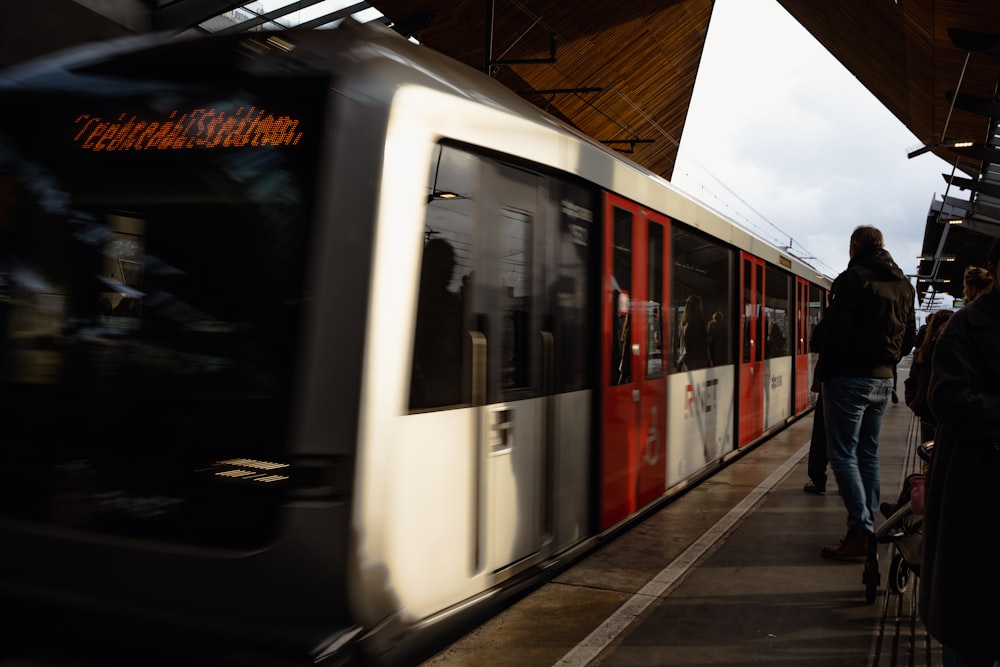 a red and white train pulling into a train station