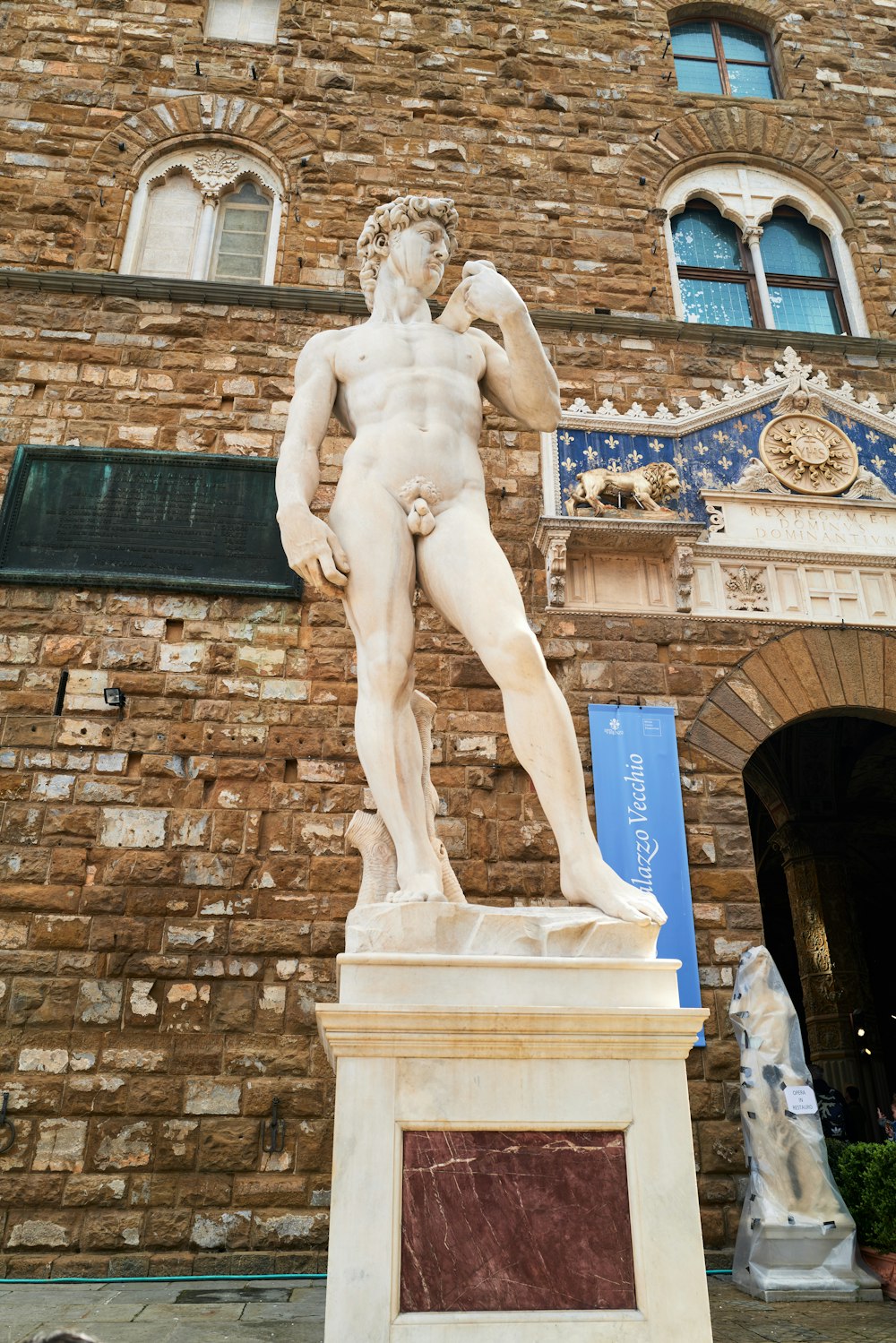 a statue of a man standing in front of a brick building