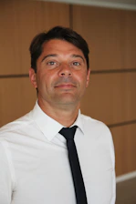 A sleek black and white photo of a focused male influencer speaking confidently in front of a camera setup.