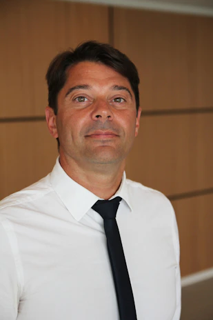 A sleek black and white photo of a focused male influencer speaking confidently in front of a camera setup.