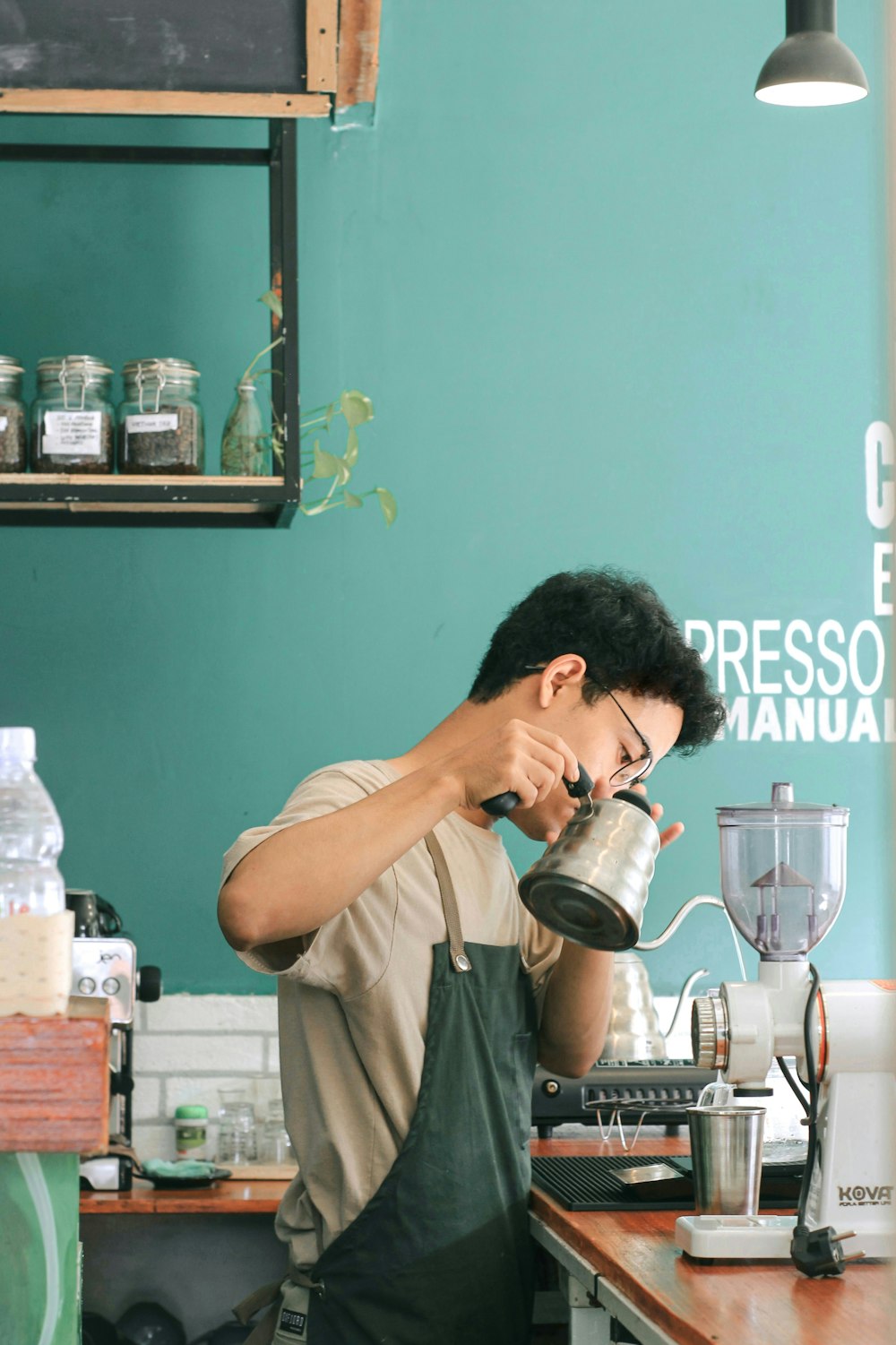 a man pouring a cup of coffee into a blender