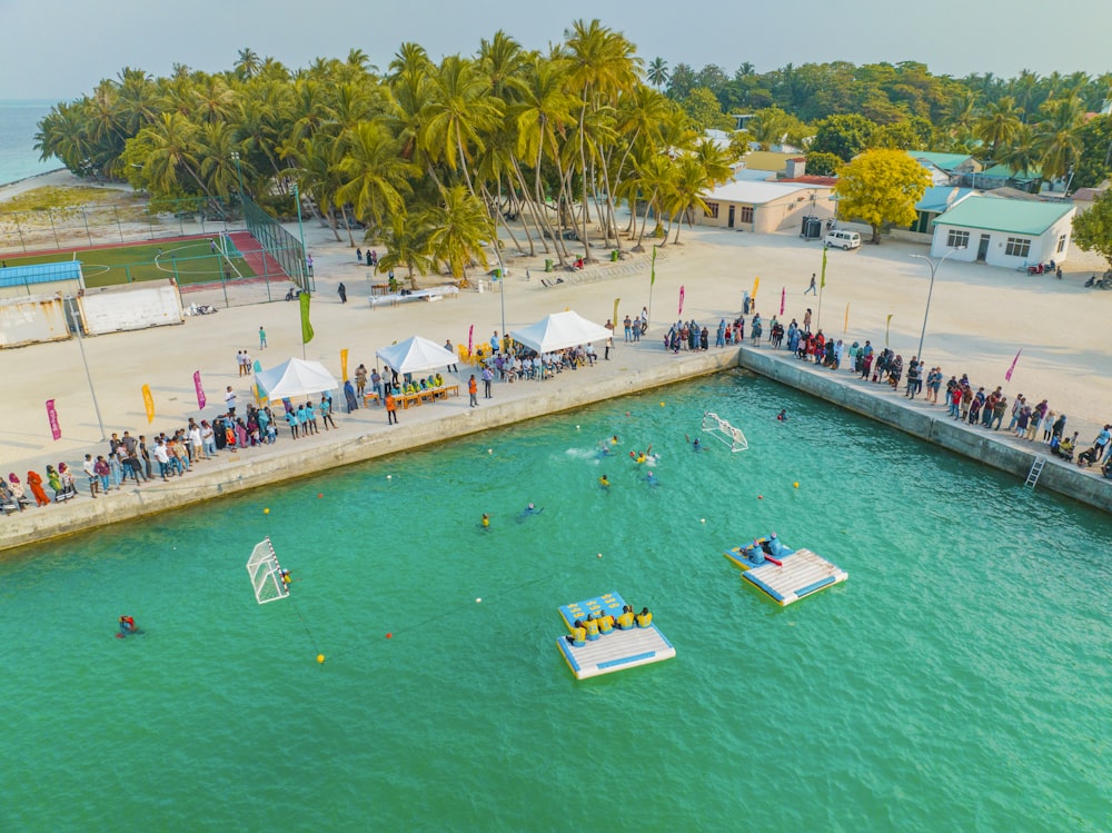 a group of people standing on a pier next to a body of water