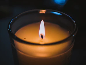 Close-up of a hand-poured candle flickering softly in a cozy urban apartment.