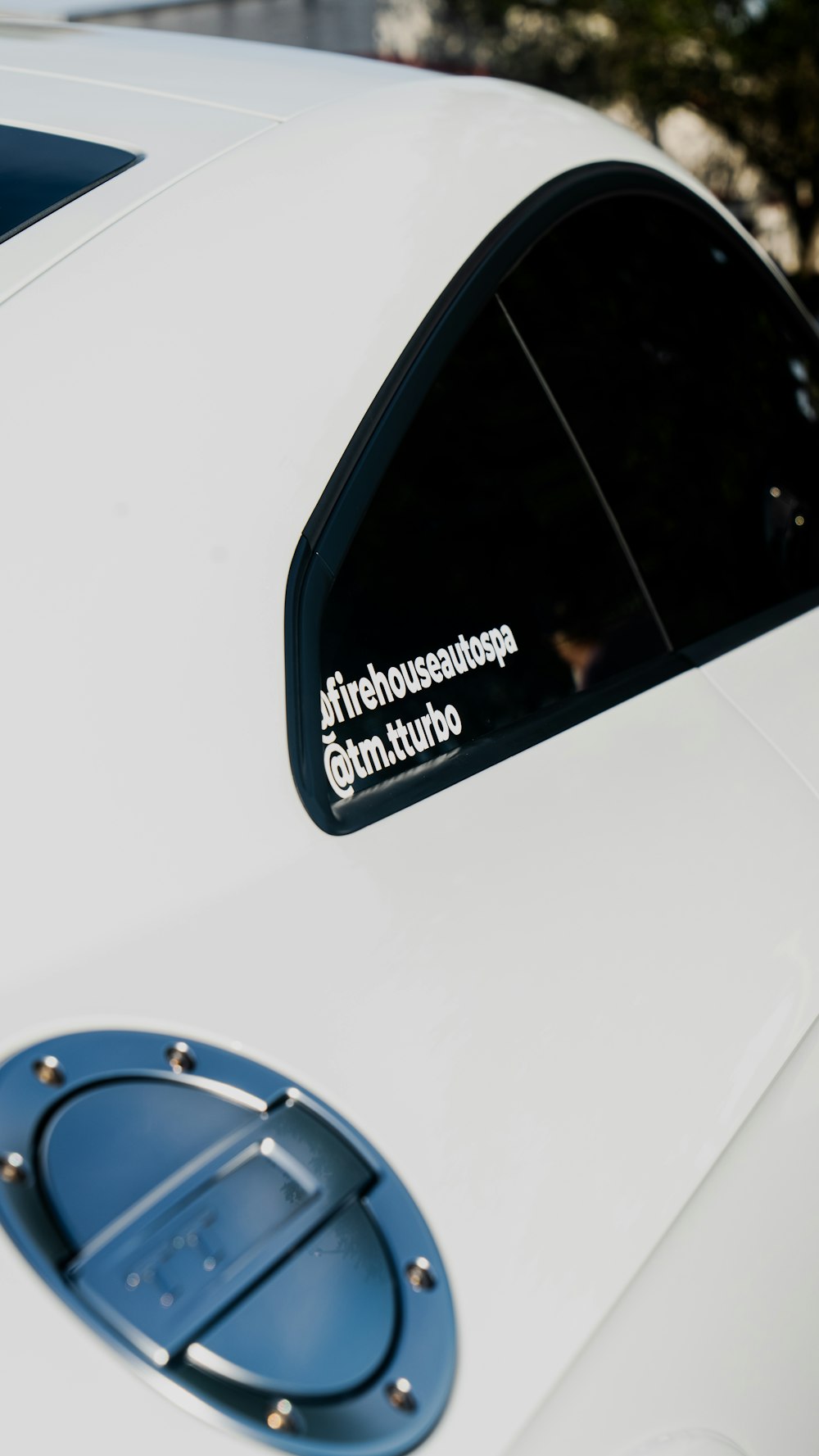 a close up of a white car with a sticker on it