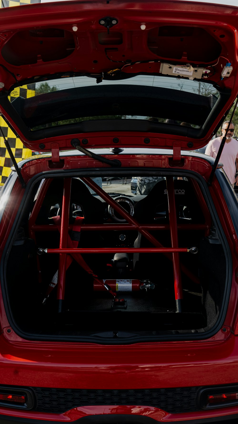 the trunk of a red car with its hood open