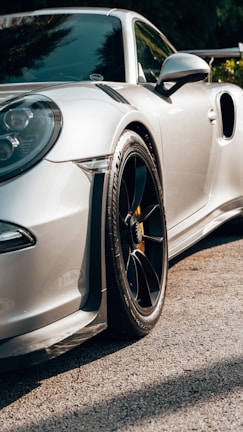 Dynamic angle of a sports car enhanced with bespoke rims and a polished finish under daylight.