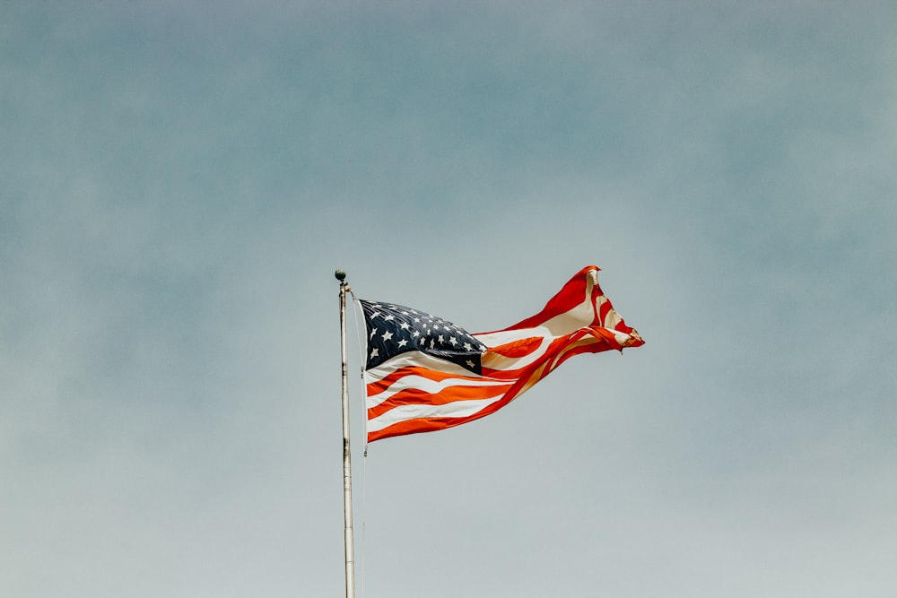 an american flag is flying in the wind