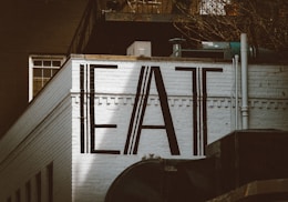 a sign that says eat on the side of a building