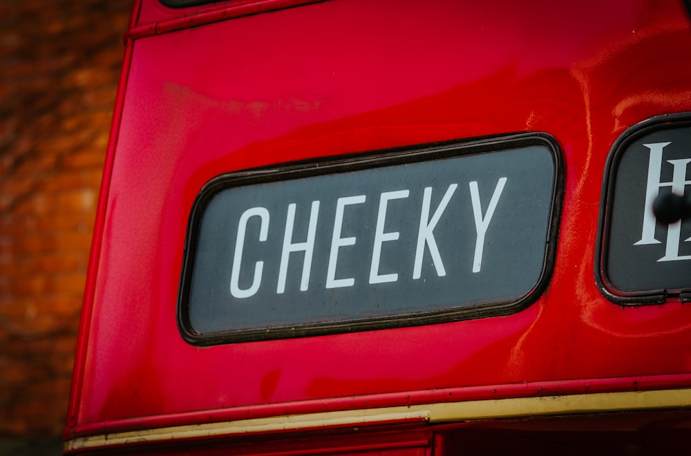 a close up of a sign on the side of a red bus
