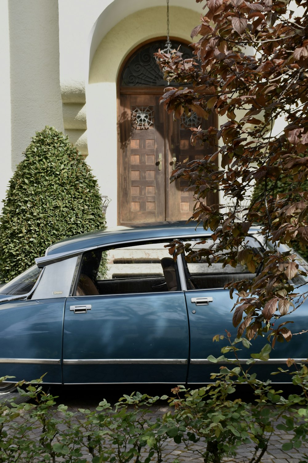 a blue car parked in front of a house