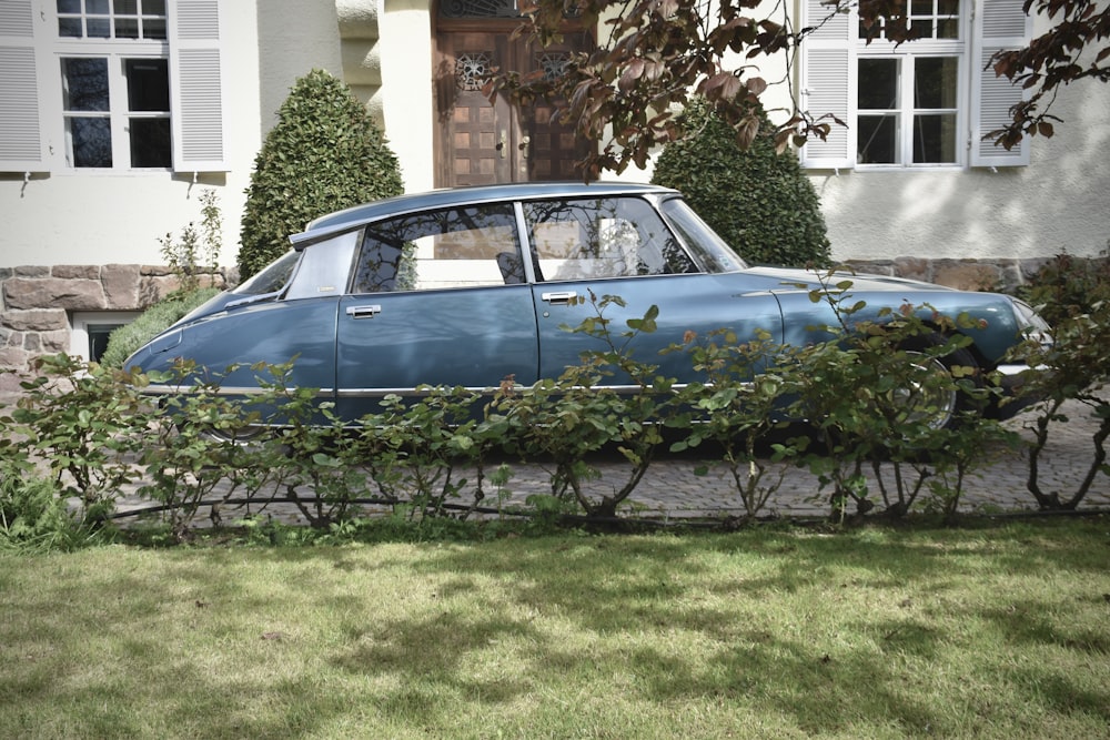 a blue car parked in front of a house