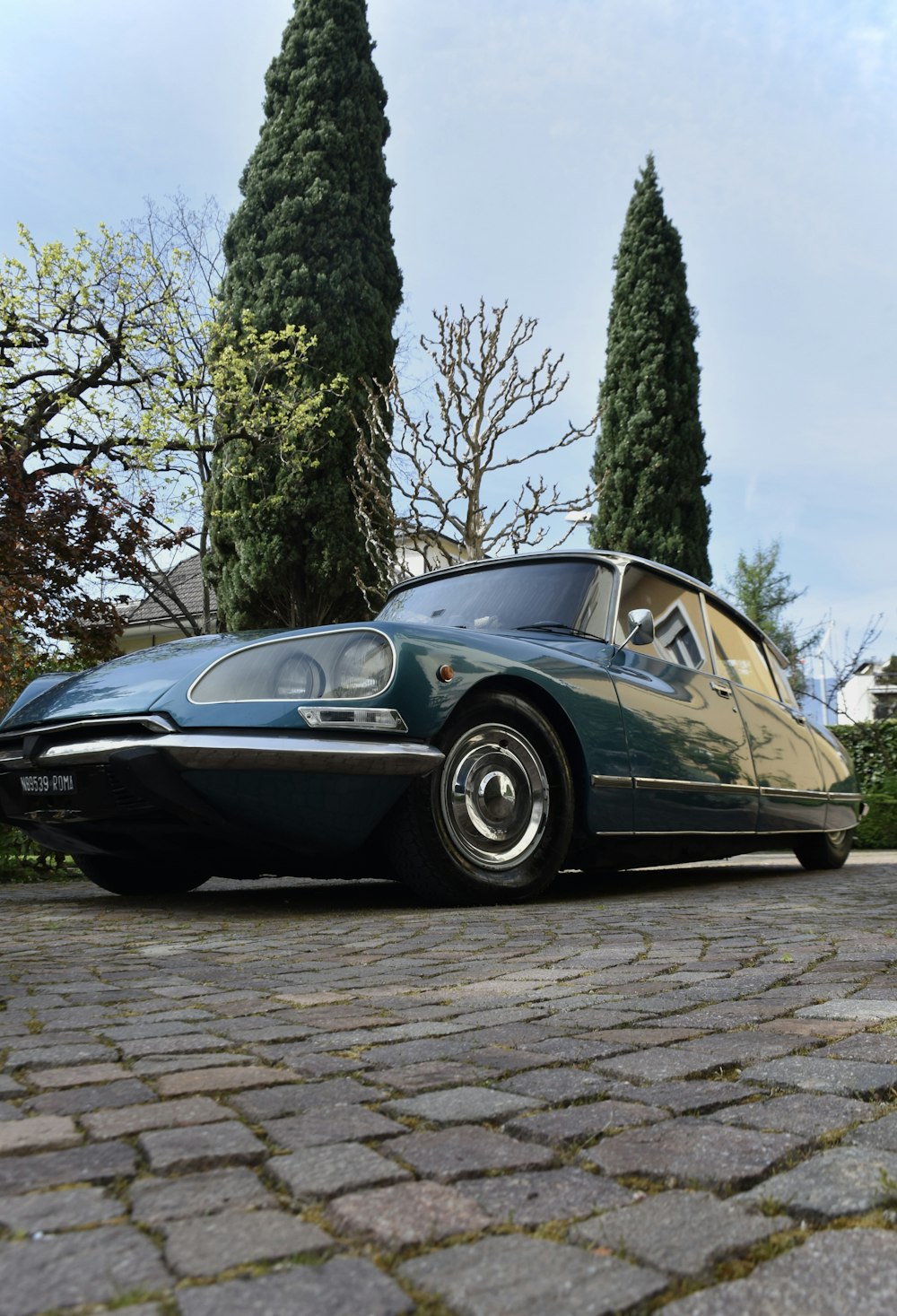 a car is parked on a cobblestone road