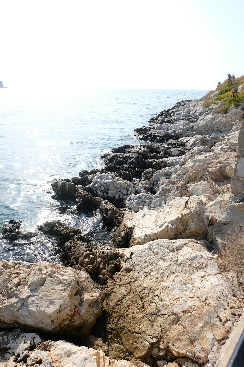 a person sitting on a bench next to the ocean