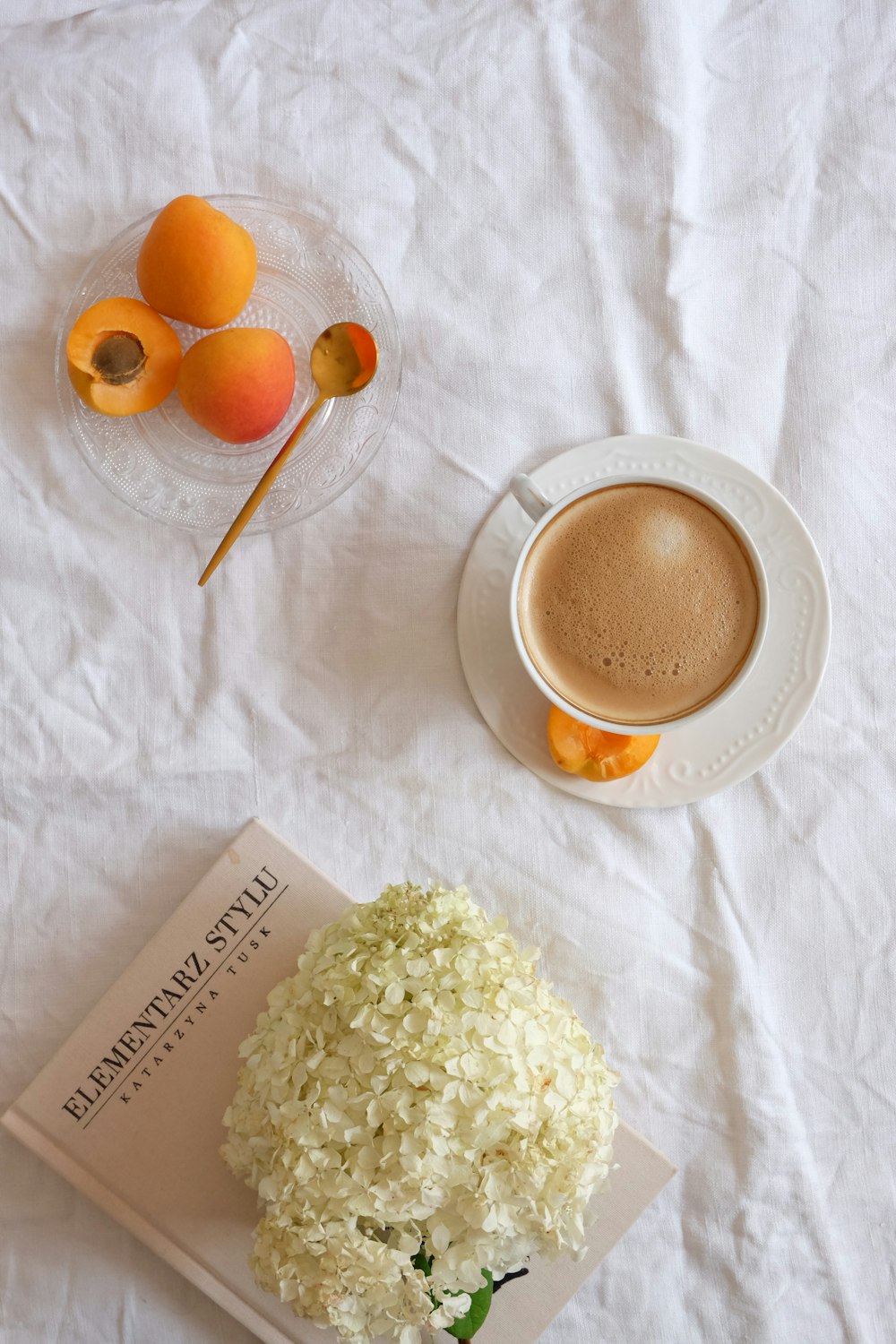 eine Tasse Kaffee und ein Buch auf einem Bett