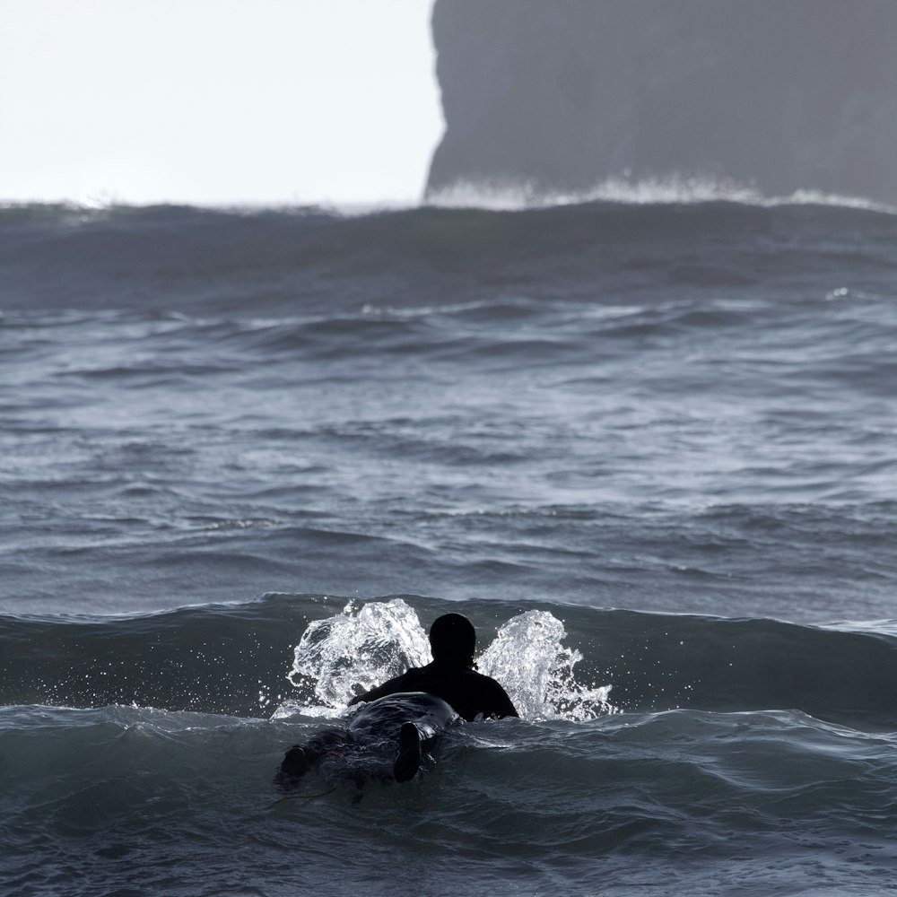 a man riding a wave on top of a surfboard