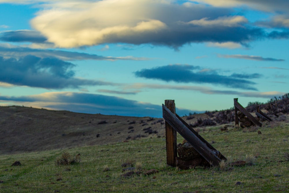 a wooden fence sitting on top of a lush green hillside